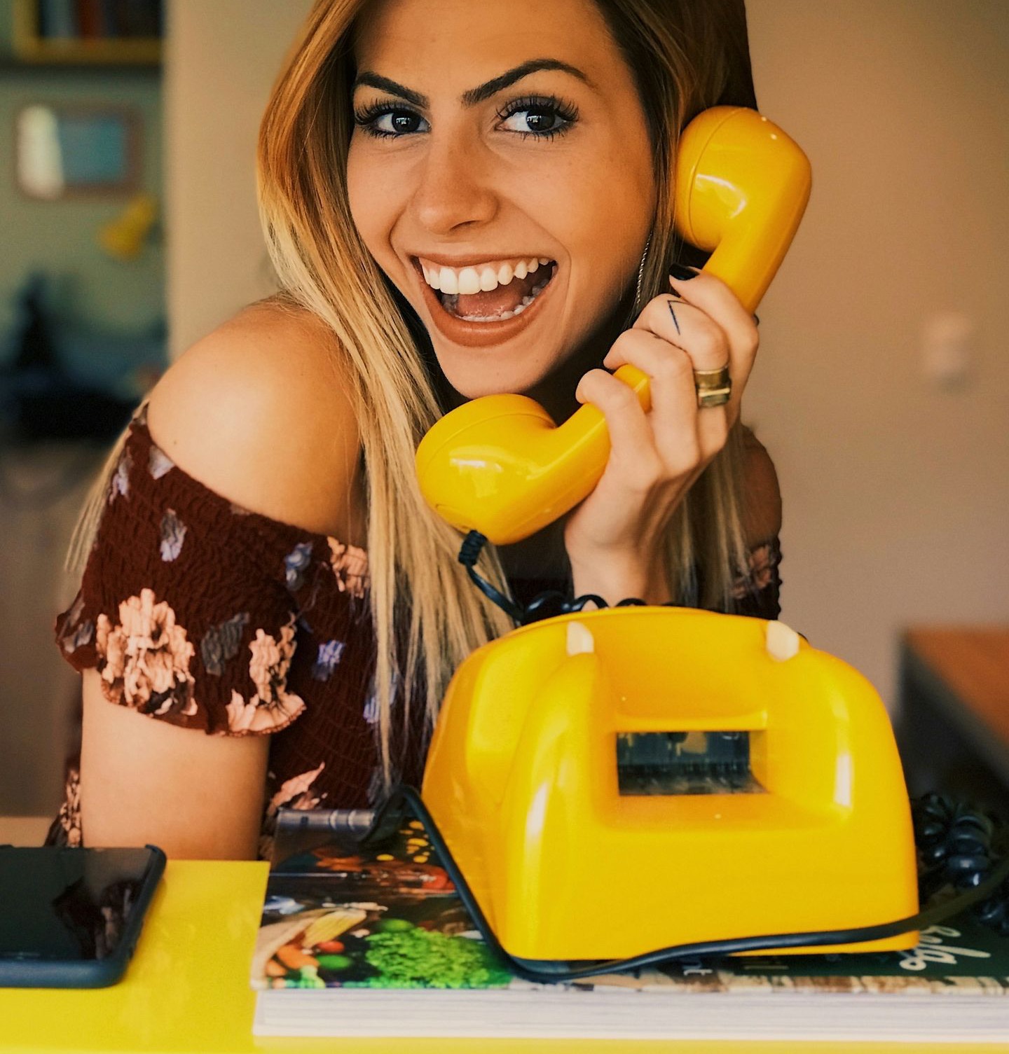 woman holding yellow rotary telephone